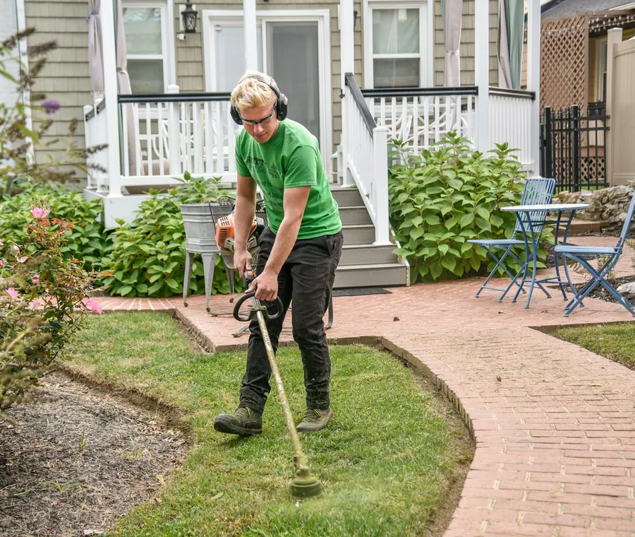 Ridgeline Outdoor Services crew member tending a landscaped yard